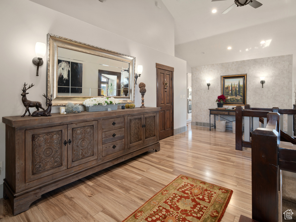 Interior space with baseboards, ceiling fan, wood finished floors, and lofted ceiling