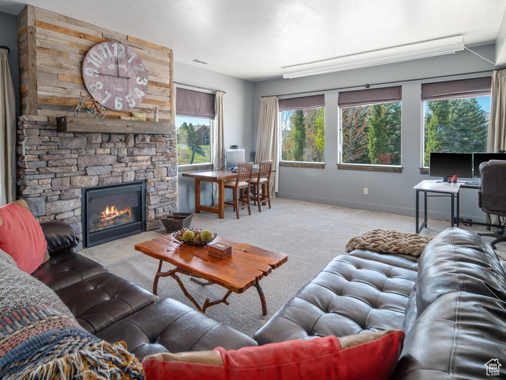Living room with carpet flooring, baseboards, and a fireplace
