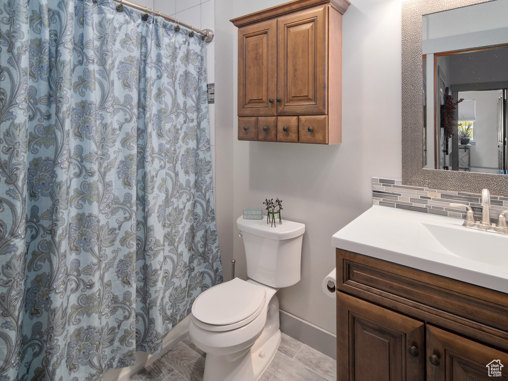 Full bath with vanity, toilet, baseboards, tasteful backsplash, and a shower with curtain