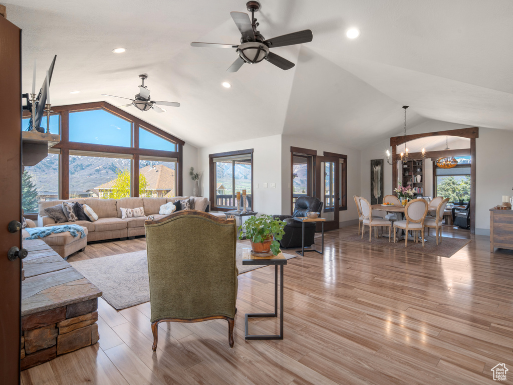 Living room featuring recessed lighting, vaulted ceiling, light wood finished floors, and ceiling fan with notable chandelier
