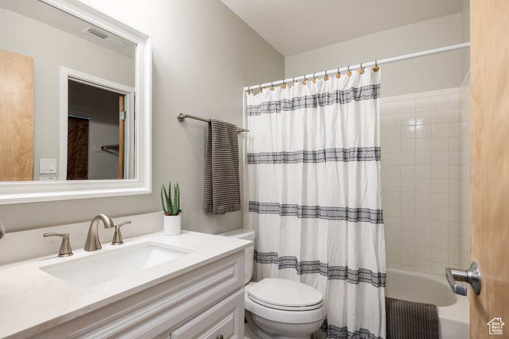 Bathroom with visible vents, shower / bath combination with curtain, toilet, and vanity