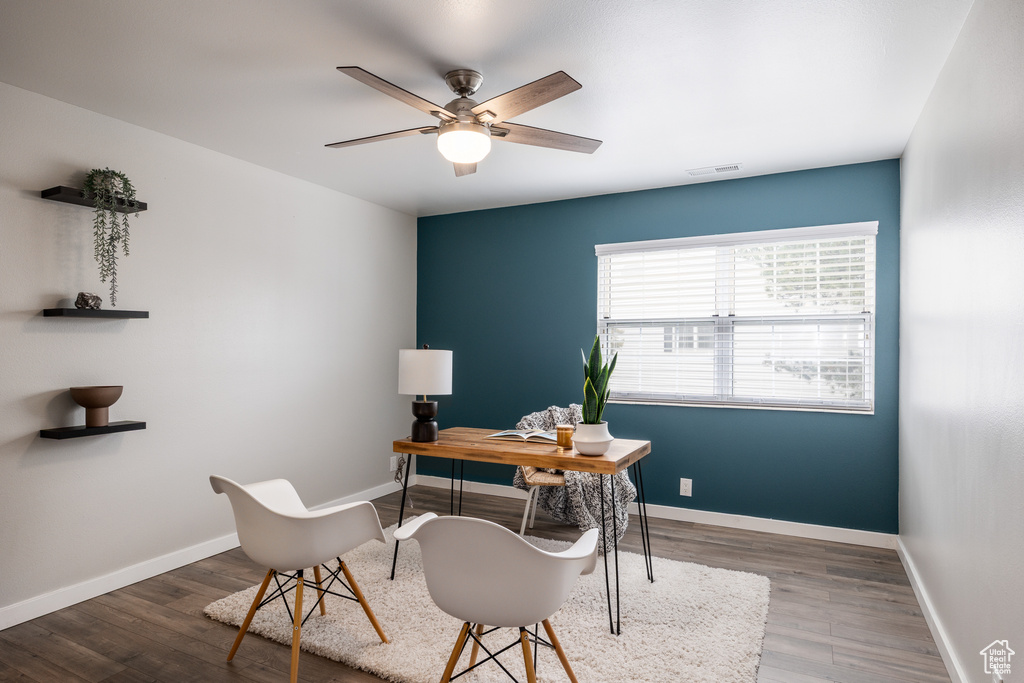 Home office with visible vents, a ceiling fan, baseboards, and wood finished floors