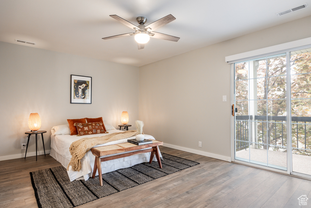 Bedroom with access to outside, baseboards, visible vents, and wood finished floors