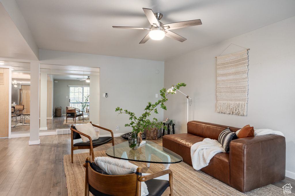 Living area with a ceiling fan, baseboards, and wood finished floors