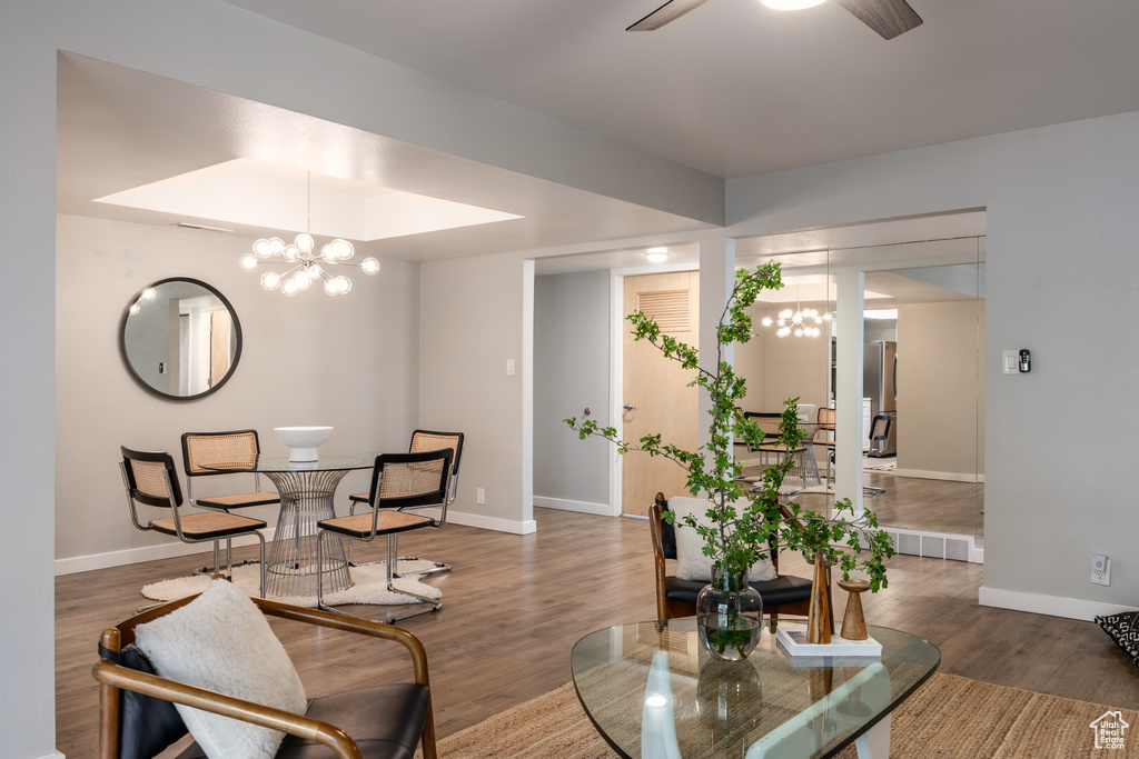 Dining room featuring baseboards, ceiling fan with notable chandelier, and wood finished floors