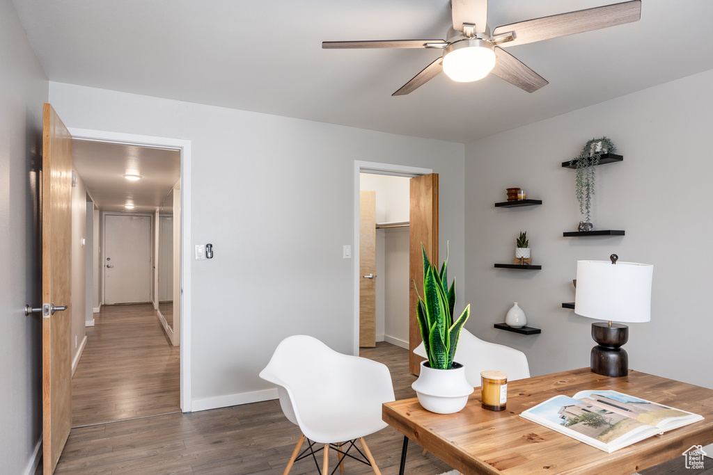 Office space featuring a ceiling fan, baseboards, and wood finished floors