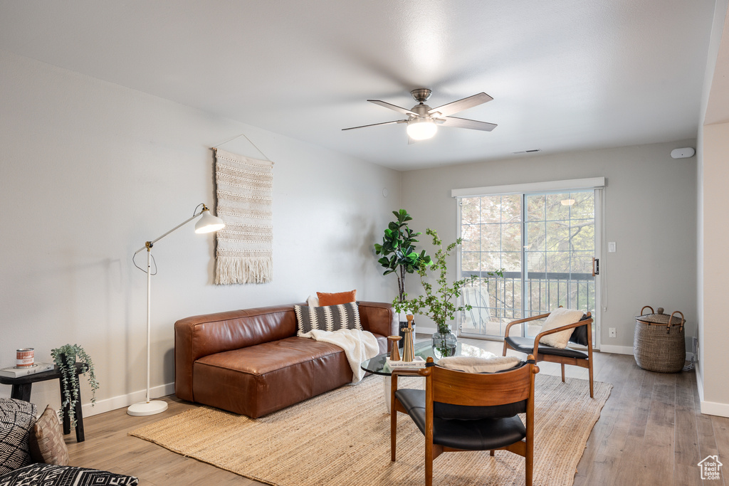 Living area with baseboards, ceiling fan, and wood finished floors