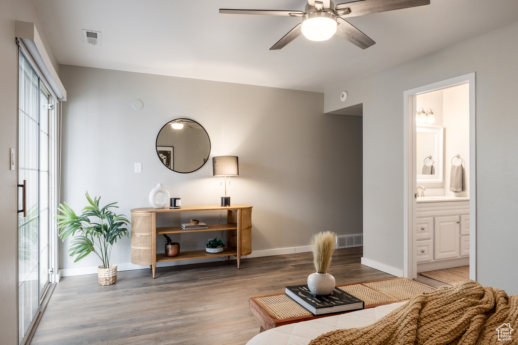 Living area featuring a ceiling fan, baseboards, visible vents, and wood finished floors