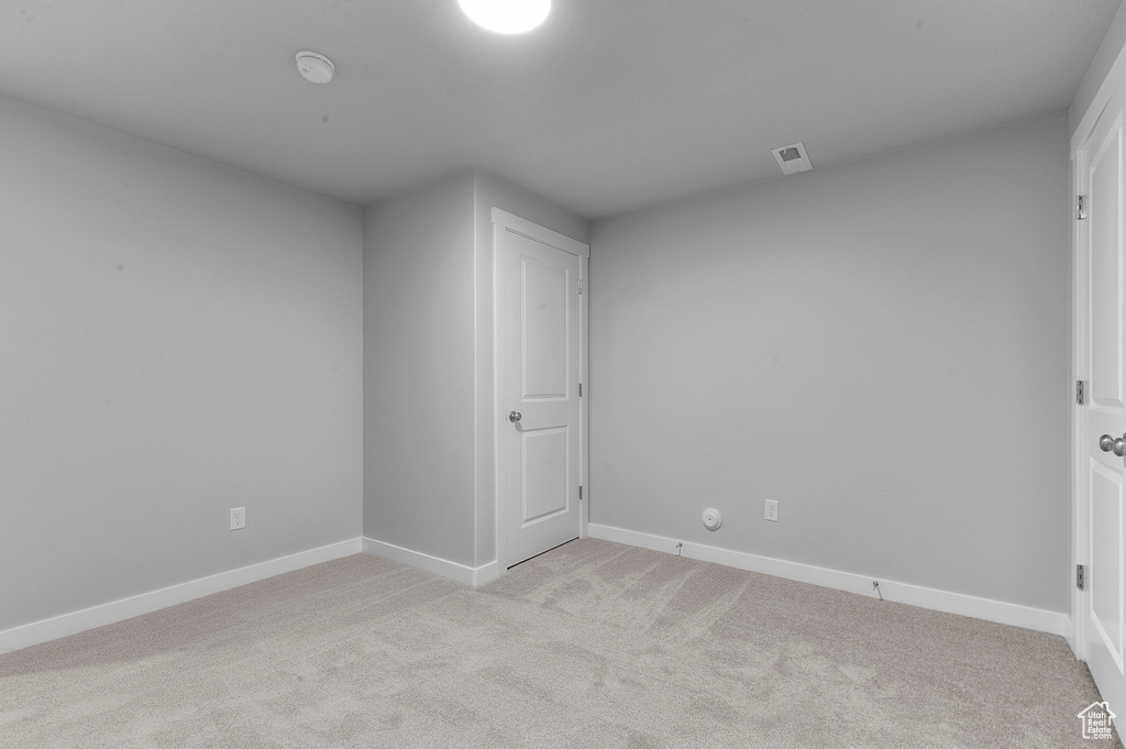 Spare room featuring baseboards, light colored carpet, and visible vents