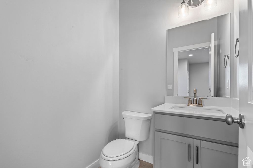 Bathroom with toilet, baseboards, and vanity
