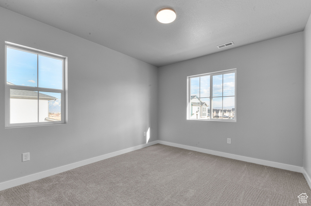Unfurnished room featuring visible vents, baseboards, and carpet floors