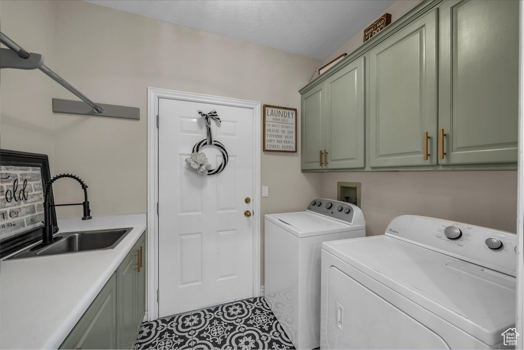 Laundry room with a sink, separate washer and dryer, and cabinet space