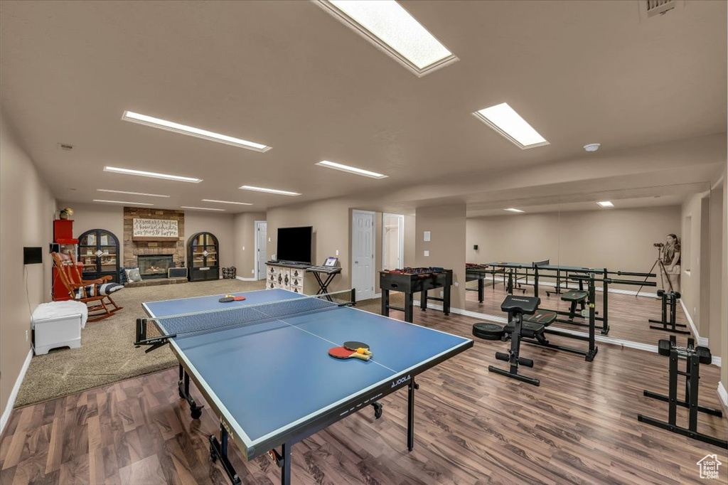 Game room featuring baseboards, a fireplace, and wood finished floors