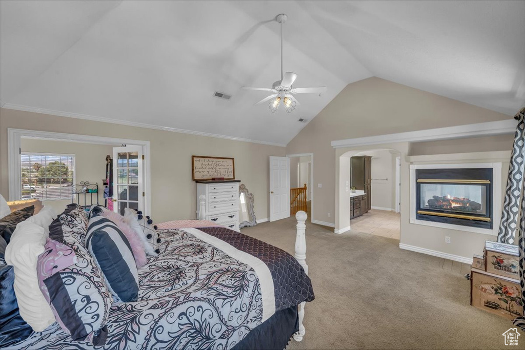 Bedroom with visible vents, light carpet, baseboards, high vaulted ceiling, and a ceiling fan