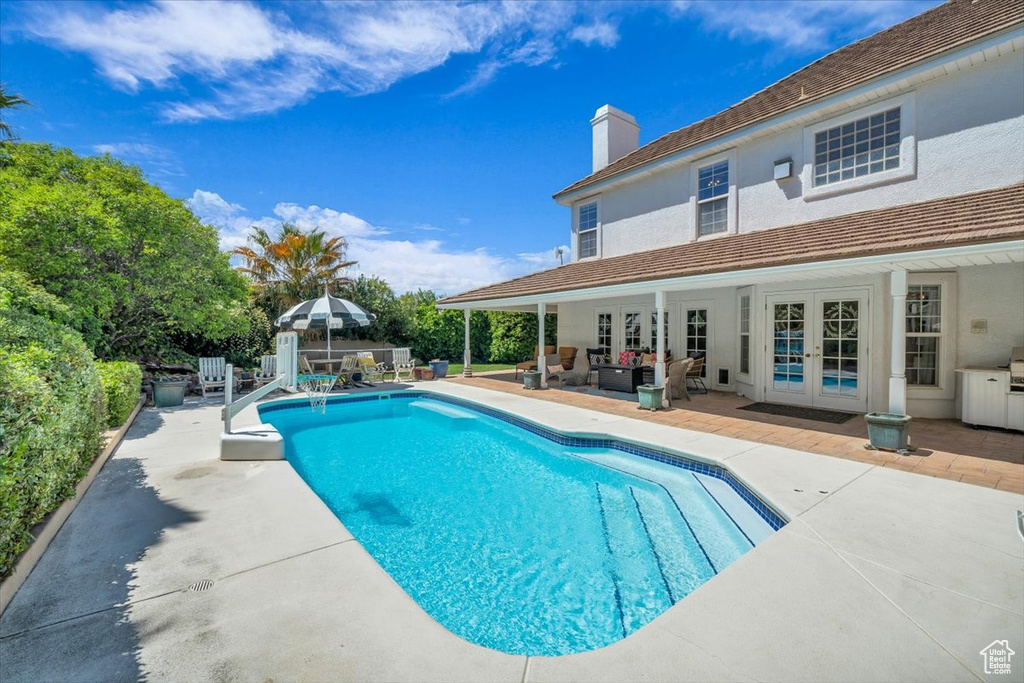 View of swimming pool with outdoor lounge area, french doors, a patio area, and a fenced in pool