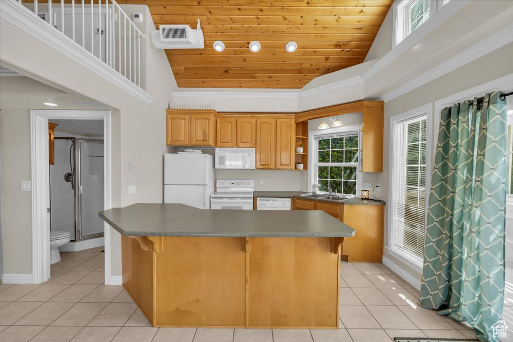 Kitchen featuring white appliances, light tile patterned flooring, dark countertops, and wooden ceiling