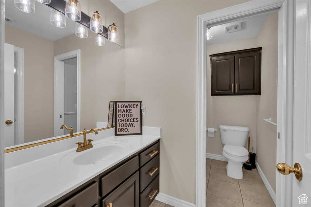 Bathroom with tile patterned flooring, vanity, toilet, baseboards, and visible vents