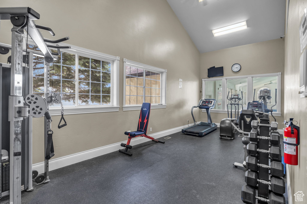 Gym featuring baseboards and high vaulted ceiling