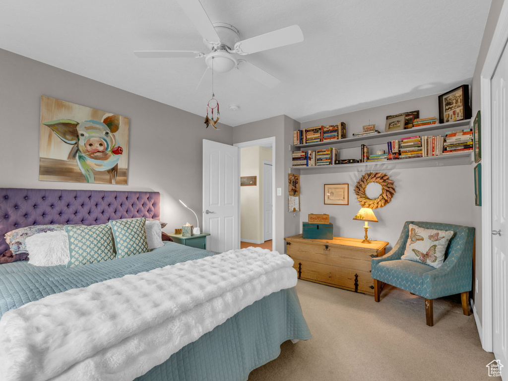 Carpeted bedroom featuring a ceiling fan