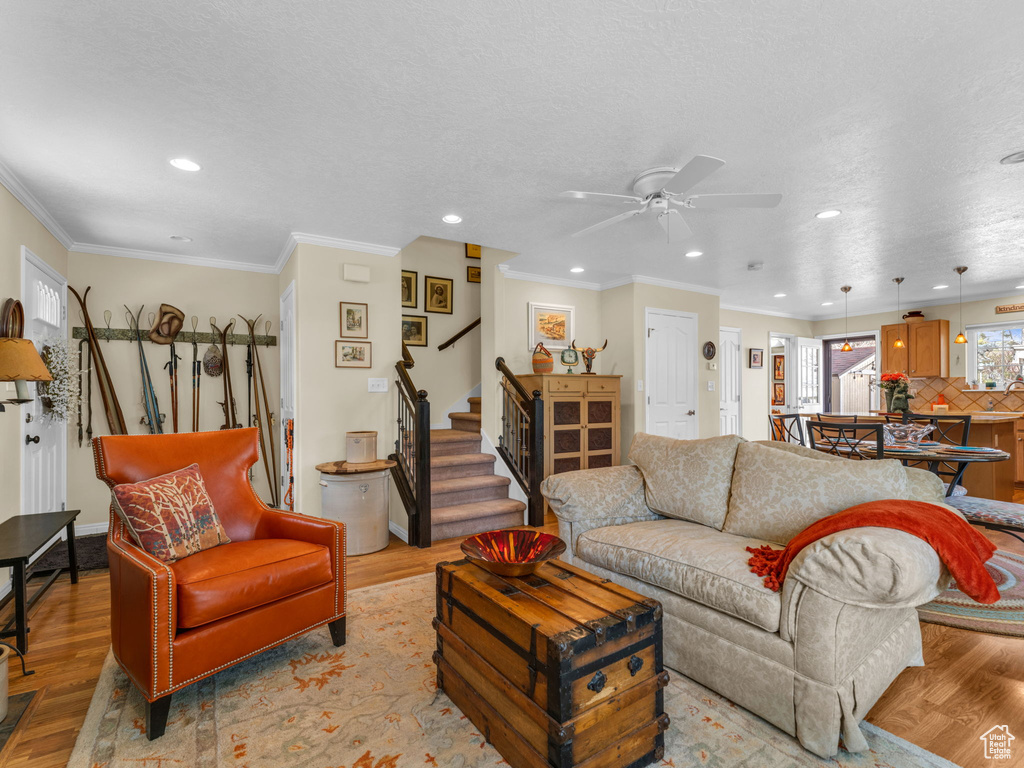 Living area with recessed lighting, ceiling fan, stairs, and wood finished floors