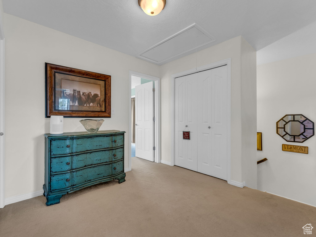 Interior space featuring a closet, attic access, and baseboards