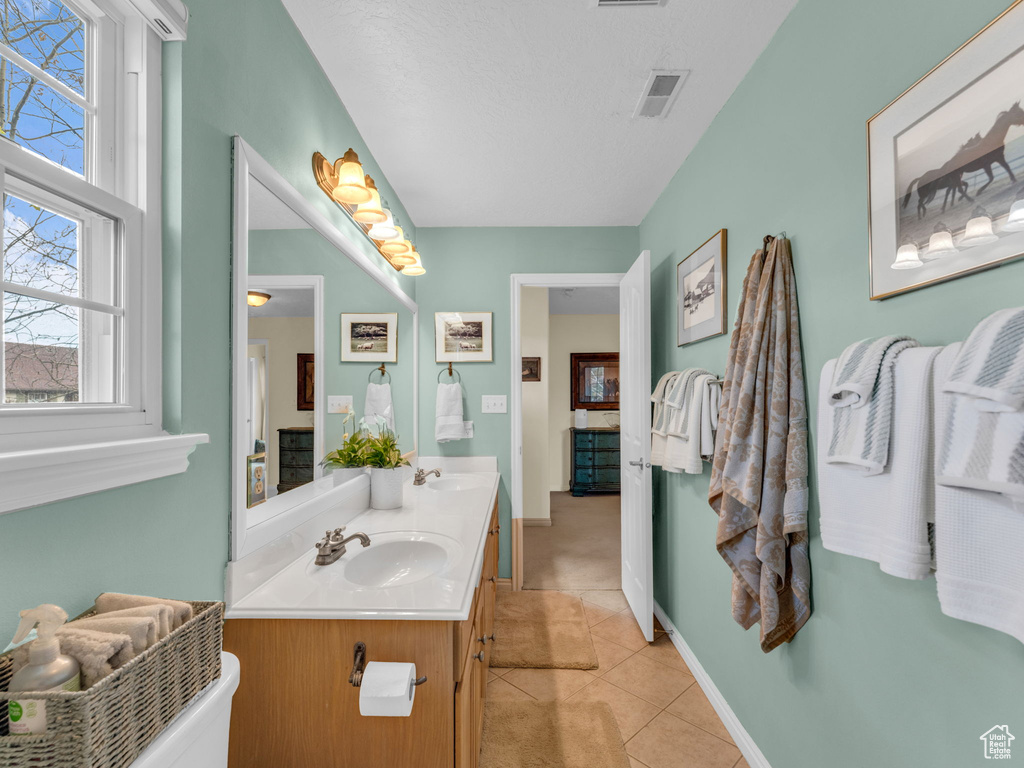 Full bathroom featuring visible vents, a sink, tile patterned flooring, and double vanity