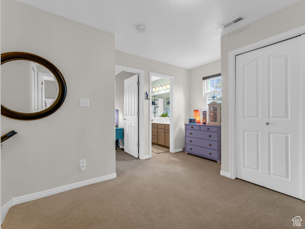 Bedroom with light colored carpet, baseboards, and visible vents
