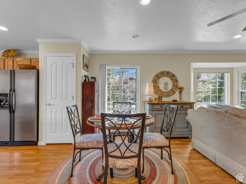 Dining space featuring crown molding, recessed lighting, light wood-style floors, and a textured ceiling