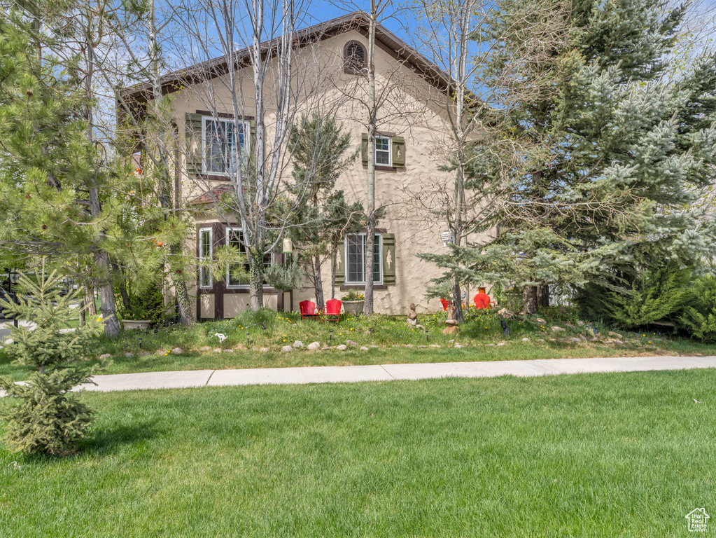 Exterior space with stucco siding and a yard