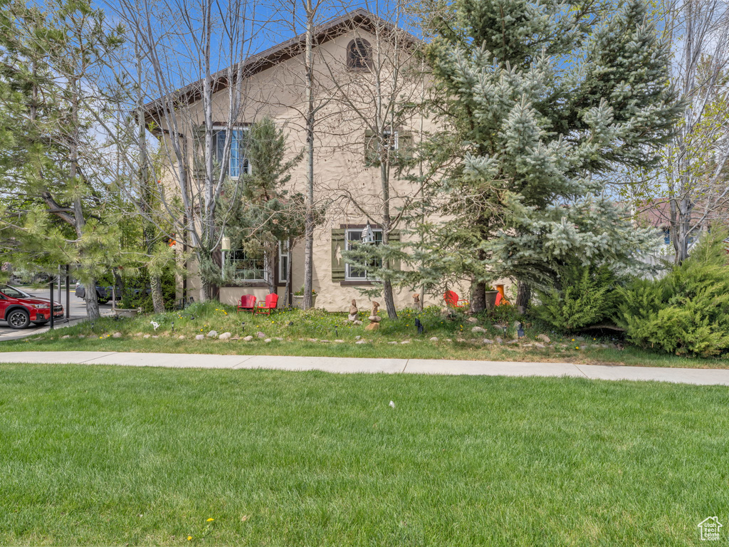 View of front of property featuring stucco siding and a front yard