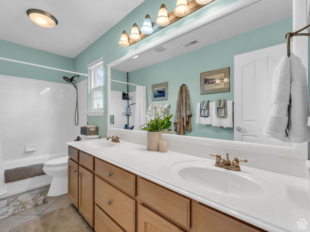 Bathroom featuring visible vents, a sink, shower / tub combo, and toilet