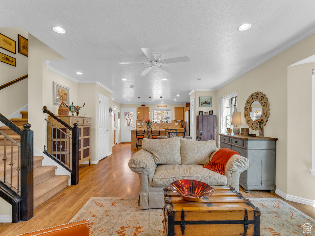 Living area with stairs, light wood-style floors, baseboards, recessed lighting, and a ceiling fan