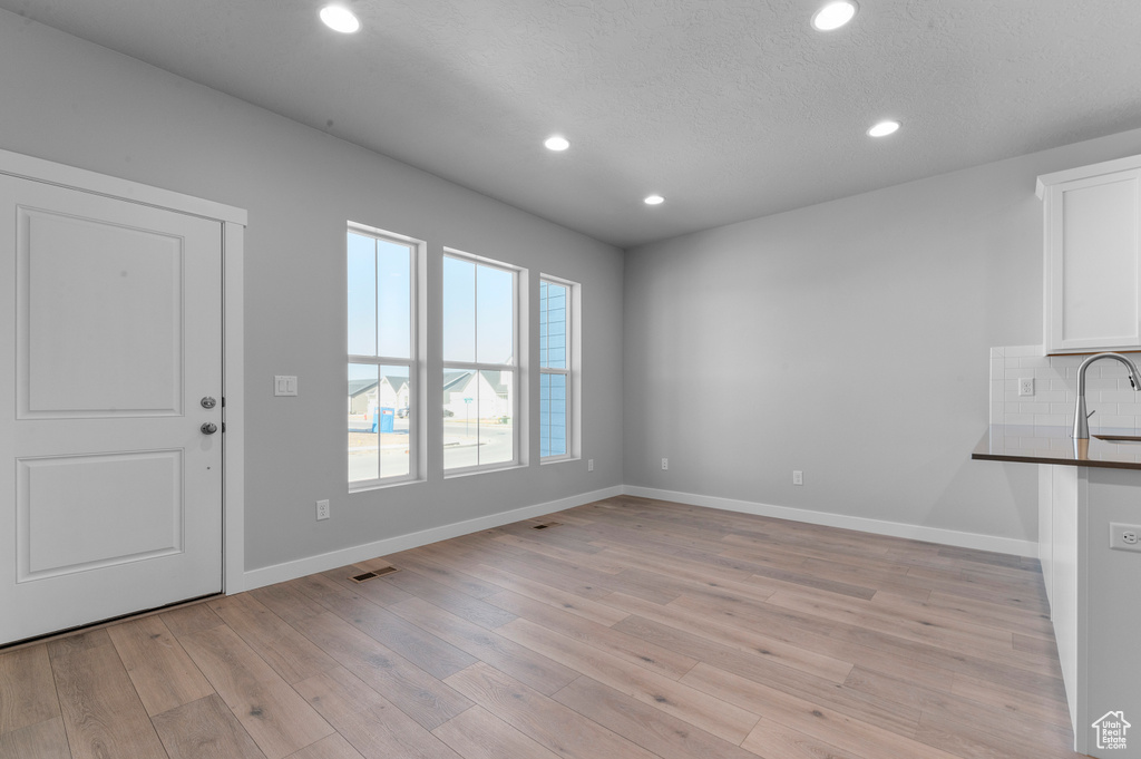 Interior space featuring recessed lighting, baseboards, visible vents, and light wood-style flooring