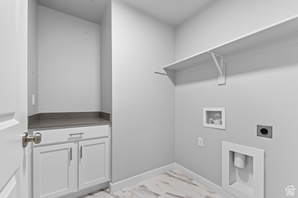 Washroom with electric dryer hookup, cabinet space, baseboards, hookup for a washing machine, and marble finish floor