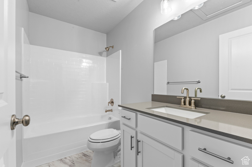 Full bathroom with vanity, marble finish floor, tub / shower combination, and toilet