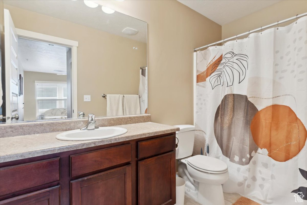 Full bathroom featuring toilet, tile patterned floors, and vanity