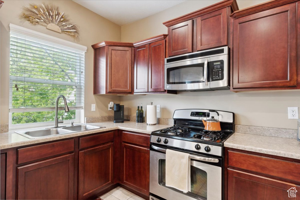 Kitchen featuring a sink, appliances with stainless steel finishes, a wealth of natural light, and light countertops