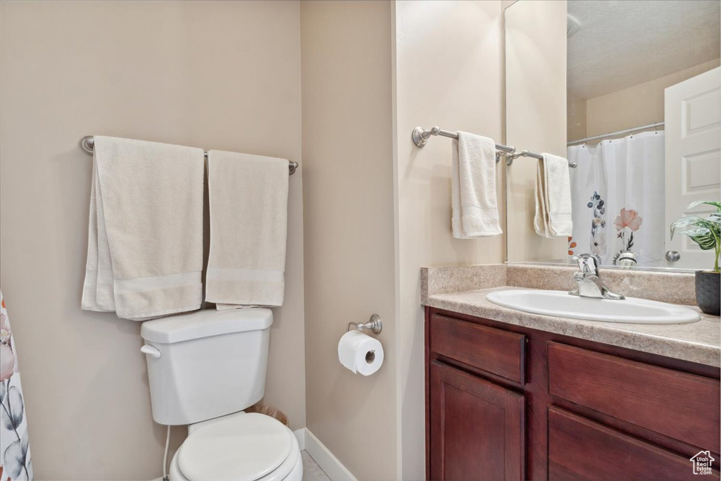 Bathroom with vanity, baseboards, and toilet