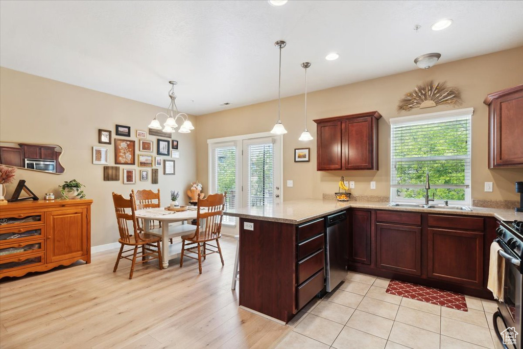 Kitchen with gas stove, a sink, a chandelier, a peninsula, and dishwashing machine