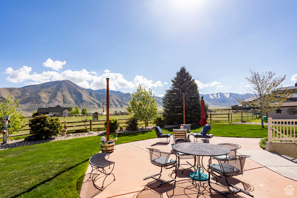 View of patio with fence and a mountain view