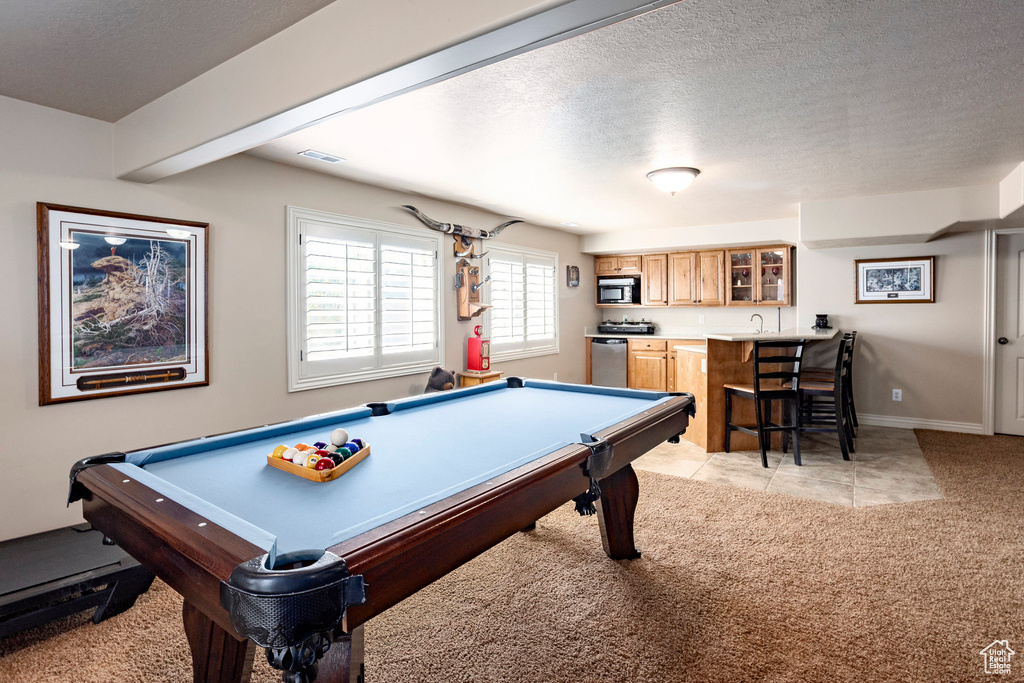Rec room with light carpet, a textured ceiling, wet bar, baseboards, and billiards