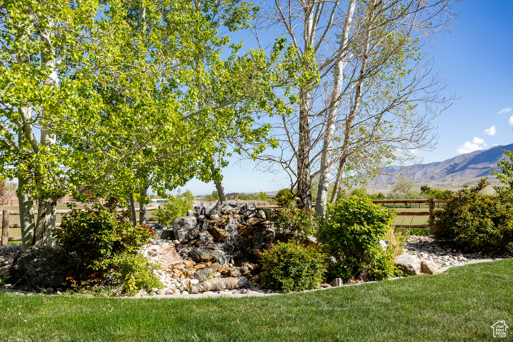 View of yard featuring a mountain view and fence