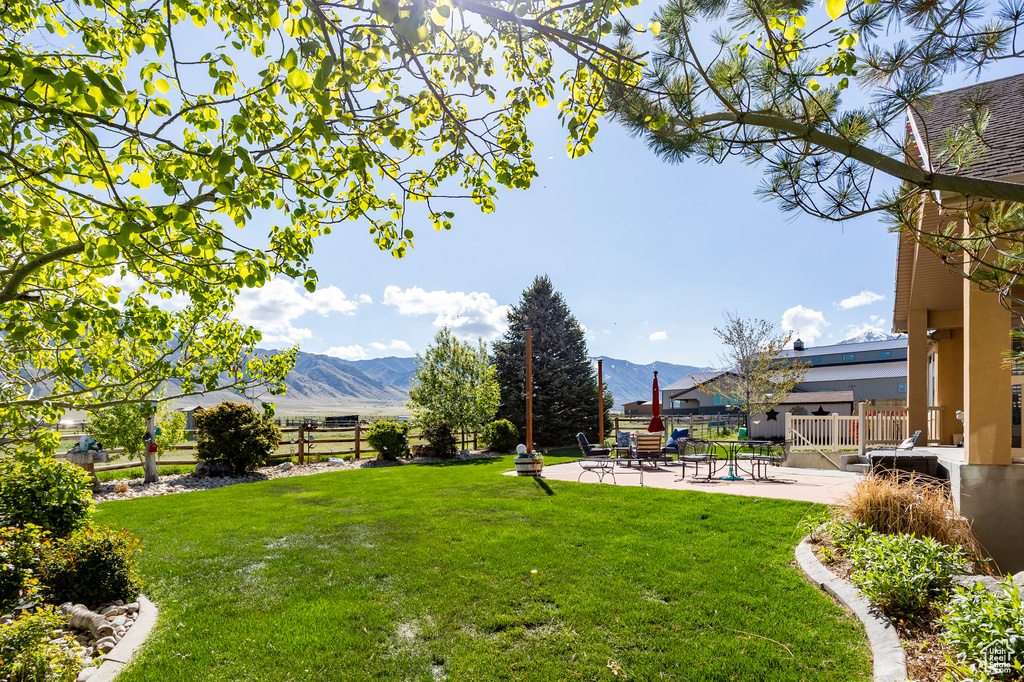 View of yard with a patio, a mountain view, and fence