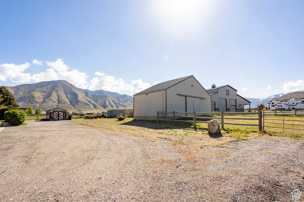 Exterior space with a mountain view, fence, and an outbuilding