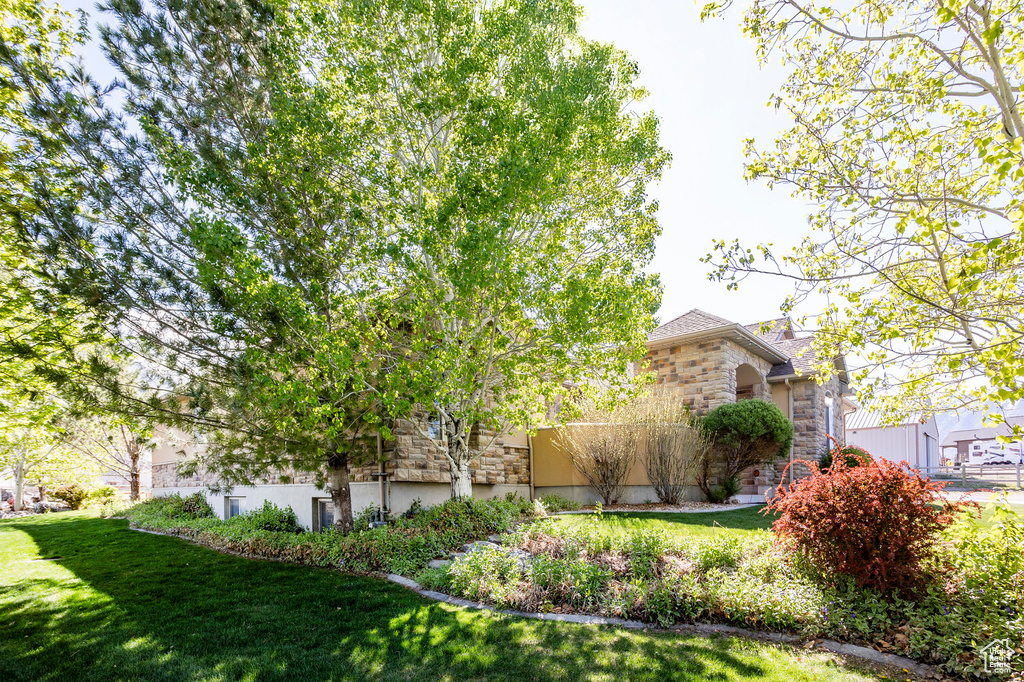 View of front facade featuring stone siding and a front lawn
