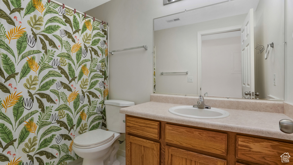 Bathroom featuring toilet, visible vents, and vanity