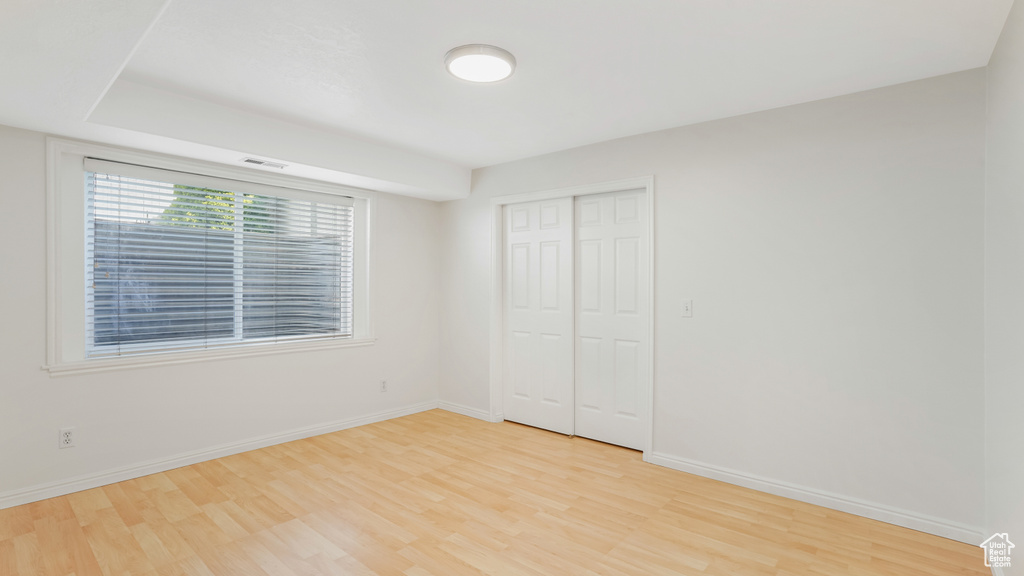Unfurnished bedroom featuring light wood-style floors, baseboards, and visible vents
