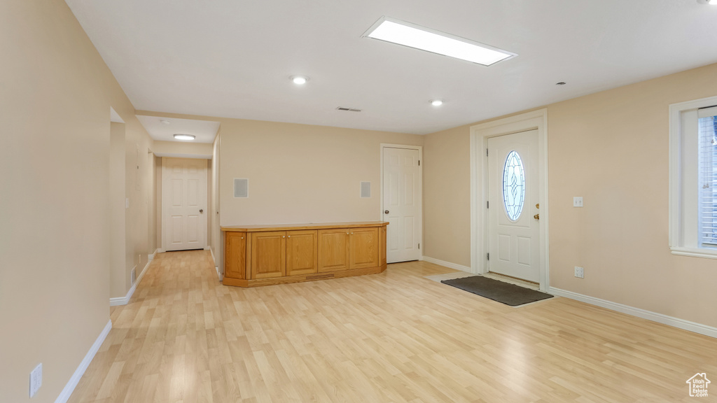 Foyer entrance with baseboards, light wood-style flooring, and a healthy amount of sunlight