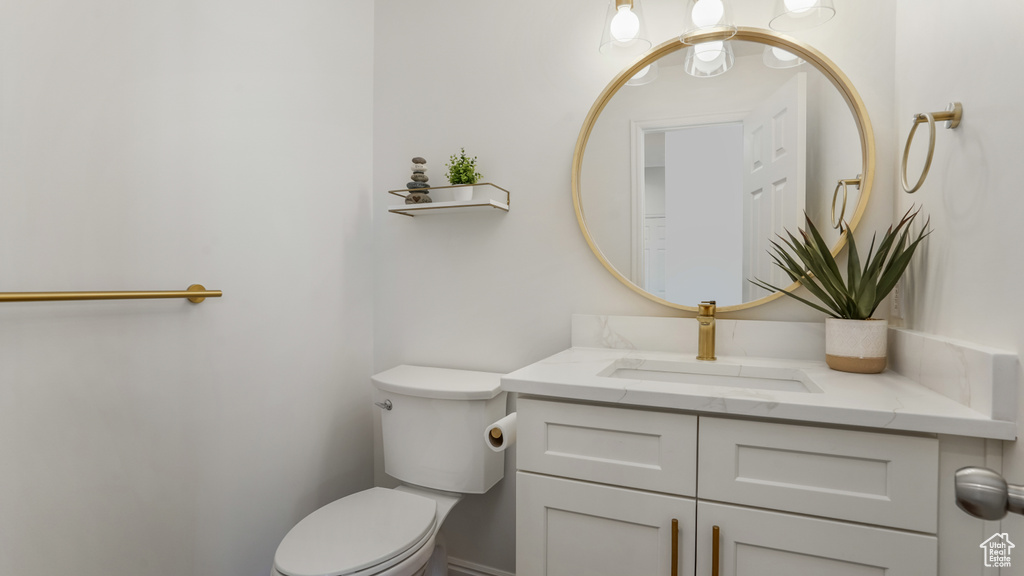 Half bath featuring toilet and vanity