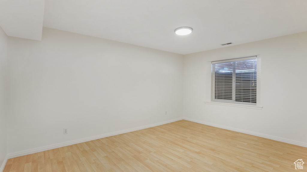 Spare room featuring baseboards, wood finished floors, and visible vents
